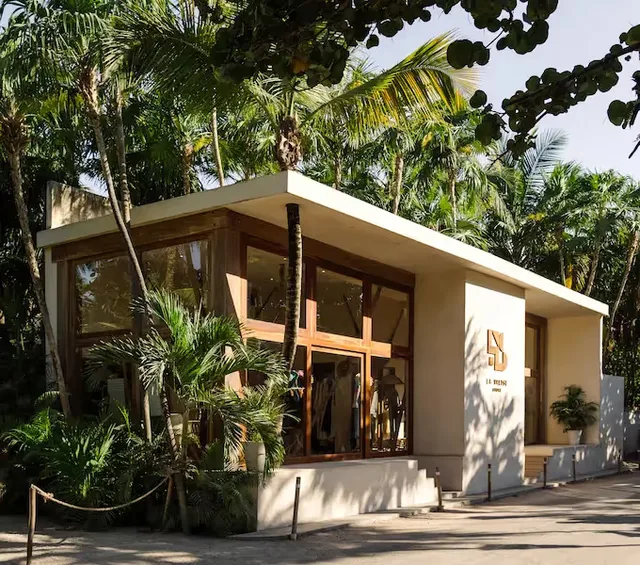 Vista exterior de la boutique de lujo en el hotel La Valise Tulum rodeada de exuberante selva tropical en México.
