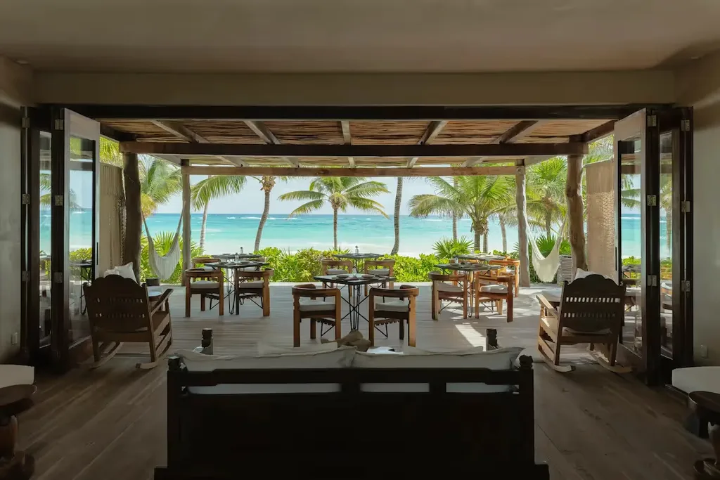 Open-air dining area of La Valise Tulum hotel restaurant overlooking the Caribbean Sea.
