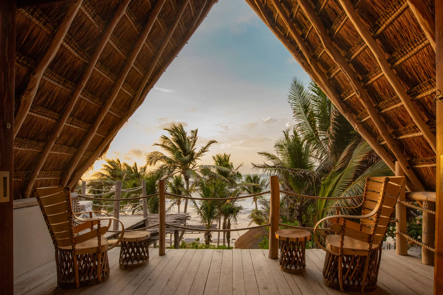 Terraza privada superior enmarcada por la palapa, con vista a las palmas y al mar — Suite Amanecer & Suite Pelícano, La Valise Tulum