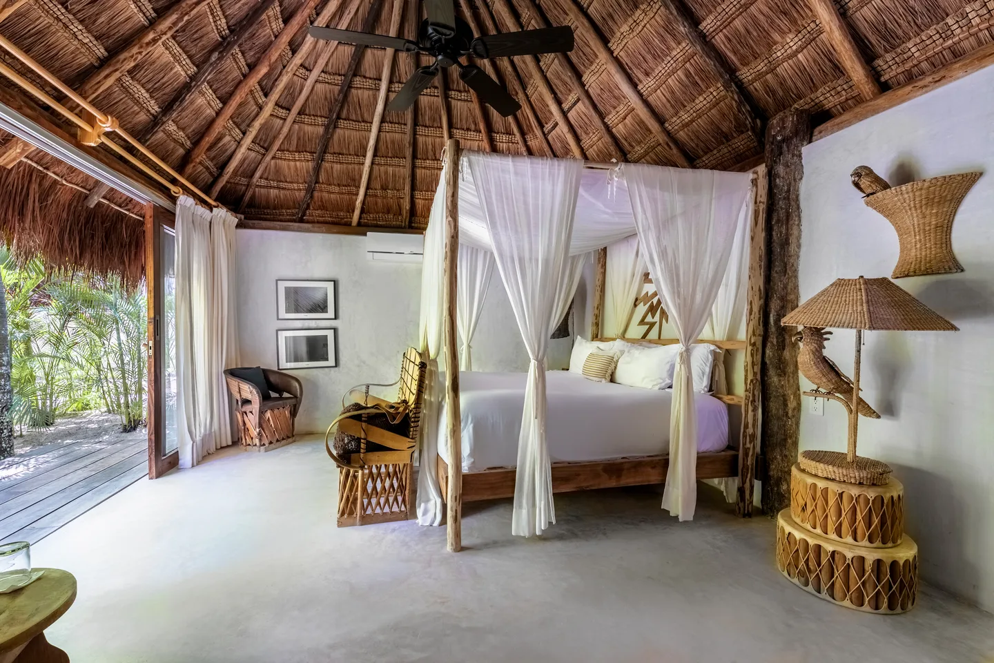 Canopied king bed beneath the thatched roof — Coconut Suite, Areca Suite, Tropical Suite & Parasol Suite, La Valise Tulum