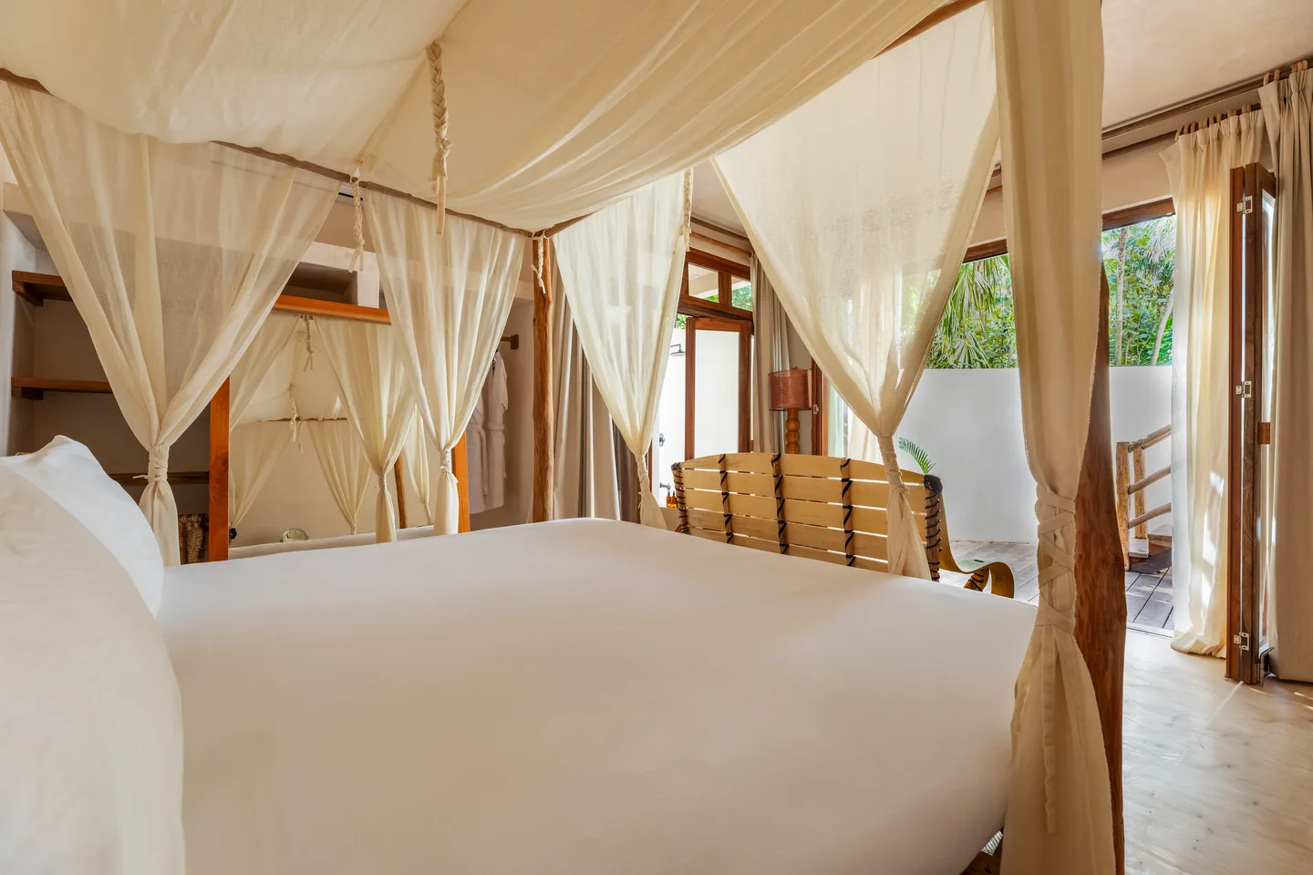 Canopied king bed with doors open to the terrace — Parrot Suite, Hammock Suite & Cacao Suite, La Valise Tulum