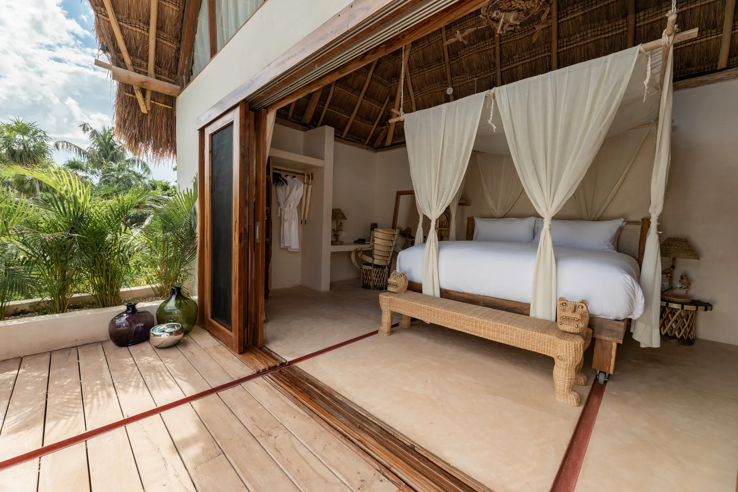 Rolling king bed opening onto the terrace under the palapa — Voyager Suite, La Valise Tulum