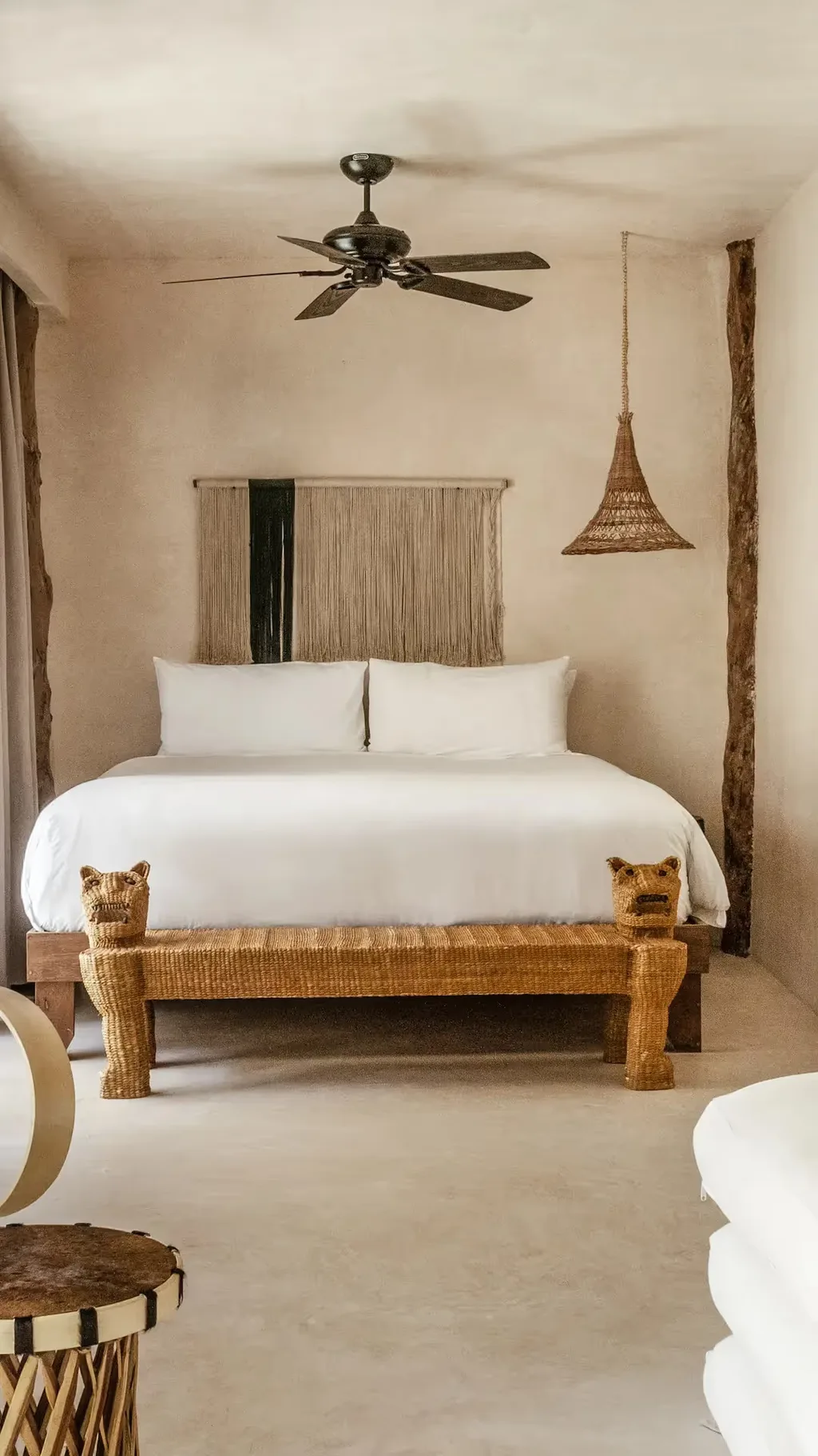 Suite elegante con cama king-size, sillón tejido y luz de ratán en La Valise Tulum.