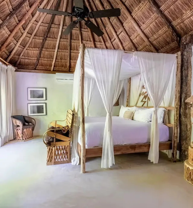 Habitación de hotel de lujo con acceso a la terraza y diseño artesanal en La Valise Tulum, México.