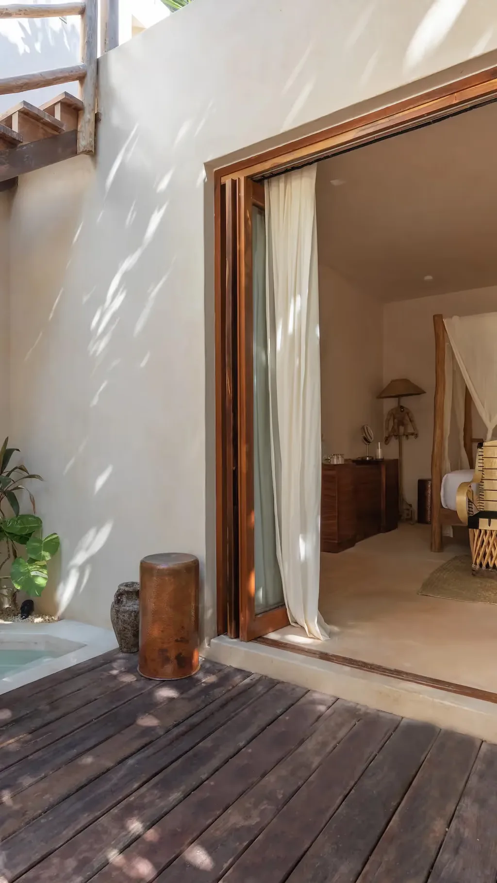 Suite de lujo en La Valise Tulum con piscina privada y acceso interior‑exterior sin interrupciones a una habitación con cama de dosel.
