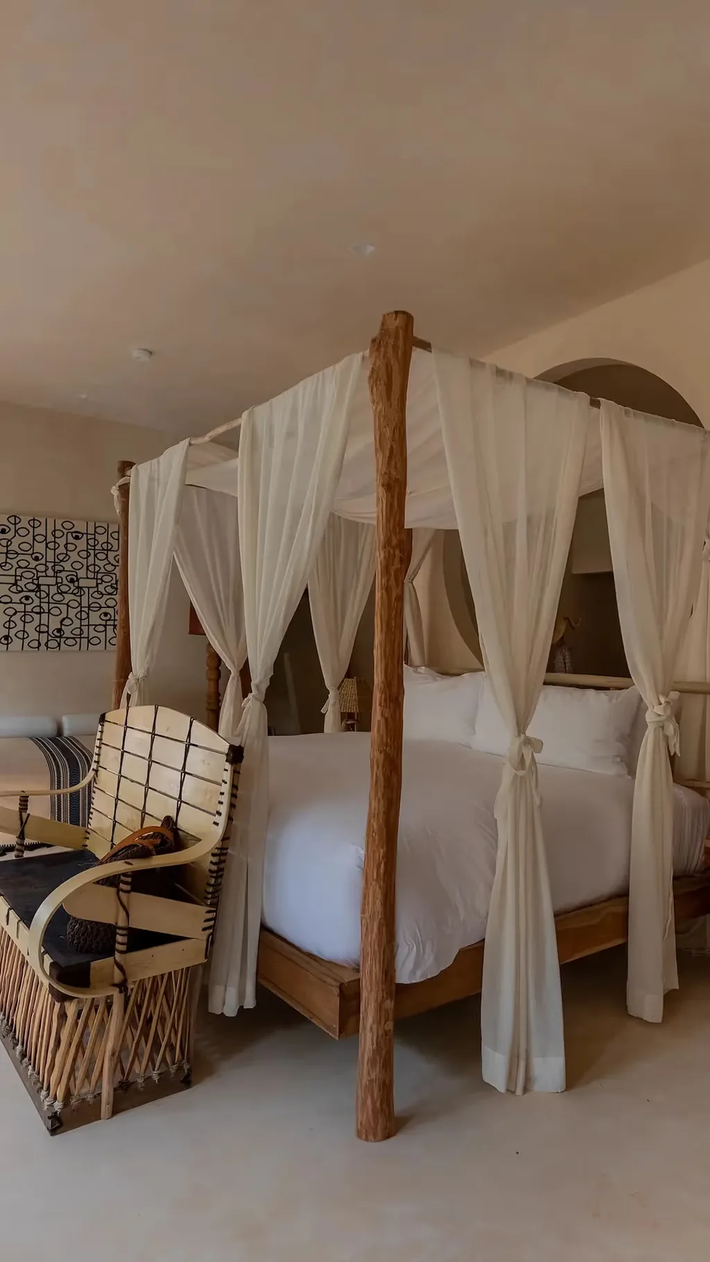 Habitación de lujo con cama con dosel de cuatro postes y ropa de cama blanca en el hotel La Valise Tulum, México.